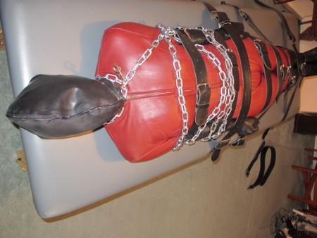 D K Bondage - Doublerubber Hooded Catsuited Strapped To The Bondage Table
