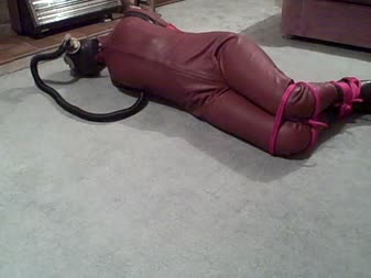 Karina Is Bound In A Leather Catsuit Rubber Armbinder And Gas M - We return to see karina has a rubber armbinder added over her leather catsuit.  The leather hood has been replaced by a rubber hood over which a gas mask has been fitted.
her legs are tied off to the bottom of the armbinder forcing her into a hogtie.  Ropes encircle her ankles and knees.
karina's predicament is heightened by a length of rubber hose being added to her gas mask.  She makes unusual noises as she breathes in and out.  Another length of tubing is added making breathing very difficult.
